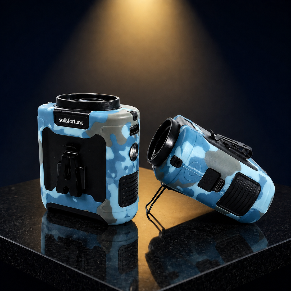 Solis Breeze waist fan in blue camo lit by a warm spotlight on a dark reflective surface