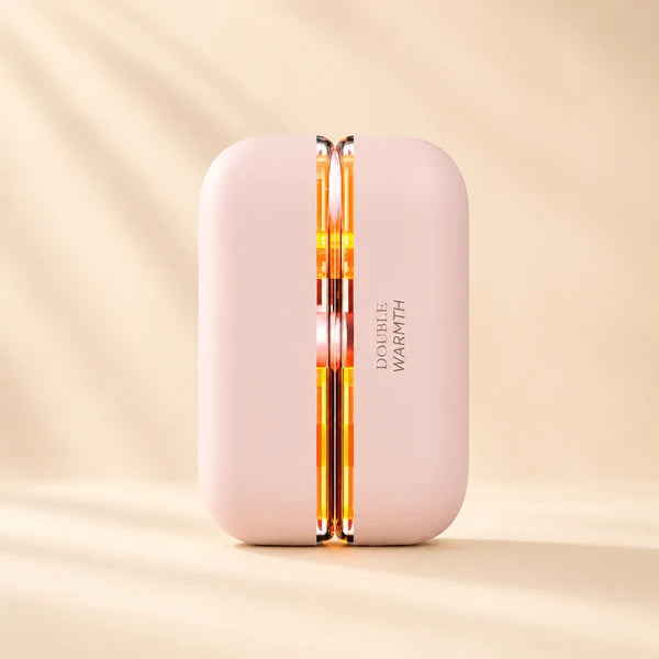 Solis Ember twin hand warmers in the Pink colourway, closed, with the seam glowing amber