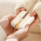 Solis Ember twin hand warmers held in two hands inside cream knitted sleeves