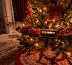 Solis Branchline — train set circling a Christmas tree with a tartan bow