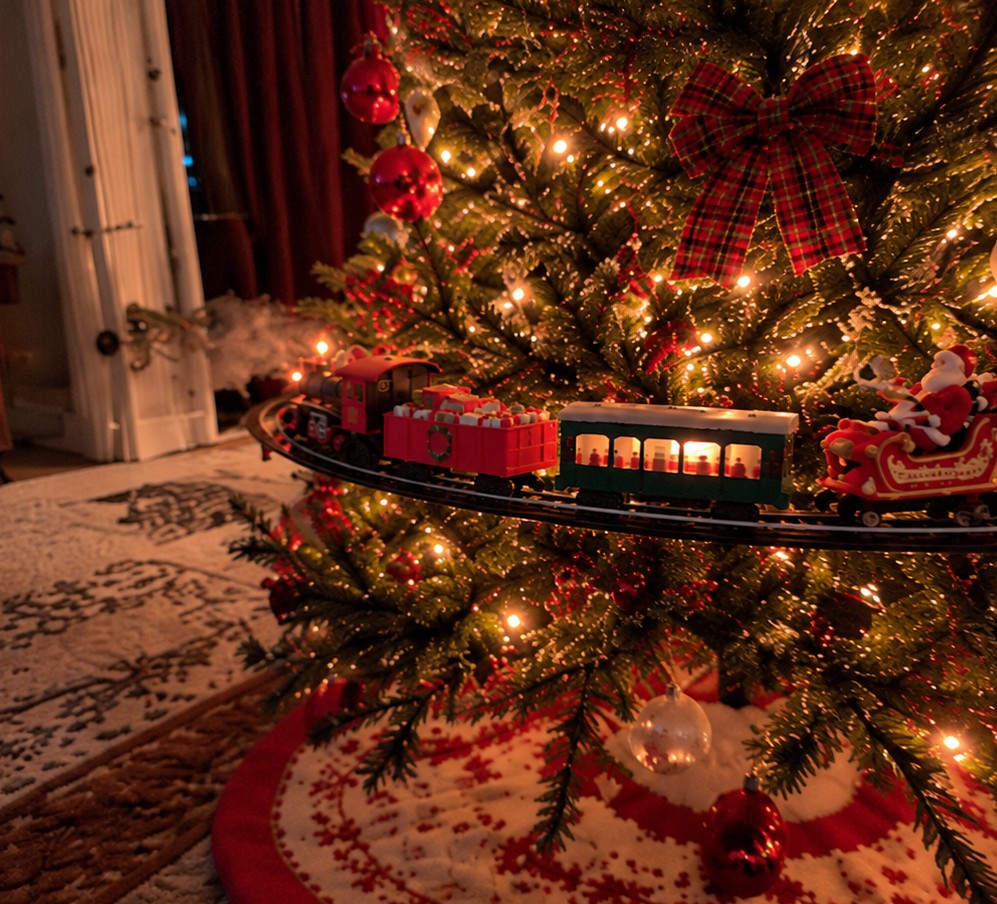 Solis Branchline — train set circling a Christmas tree with a tartan bow
