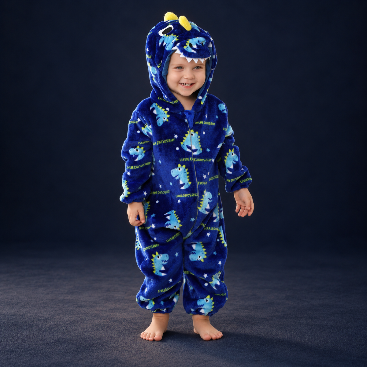 solis critter onesie dino print — Dino Print worn by a child on a dark navy studio background