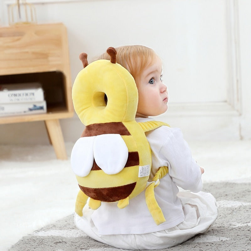 Solis Cushy — toddler wearing the bee head protector backpack while sitting on the floor