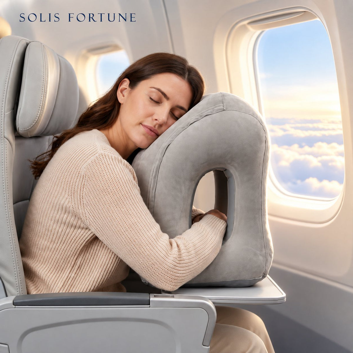 Solis Drift Travel Sleep Pillow in grey on an airplane tray table with a woman asleep against it