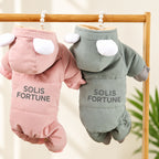 Solis Frostpaw — pink and blue-grey dog winter jumpsuits with cartoon-eye hoods on a hanger