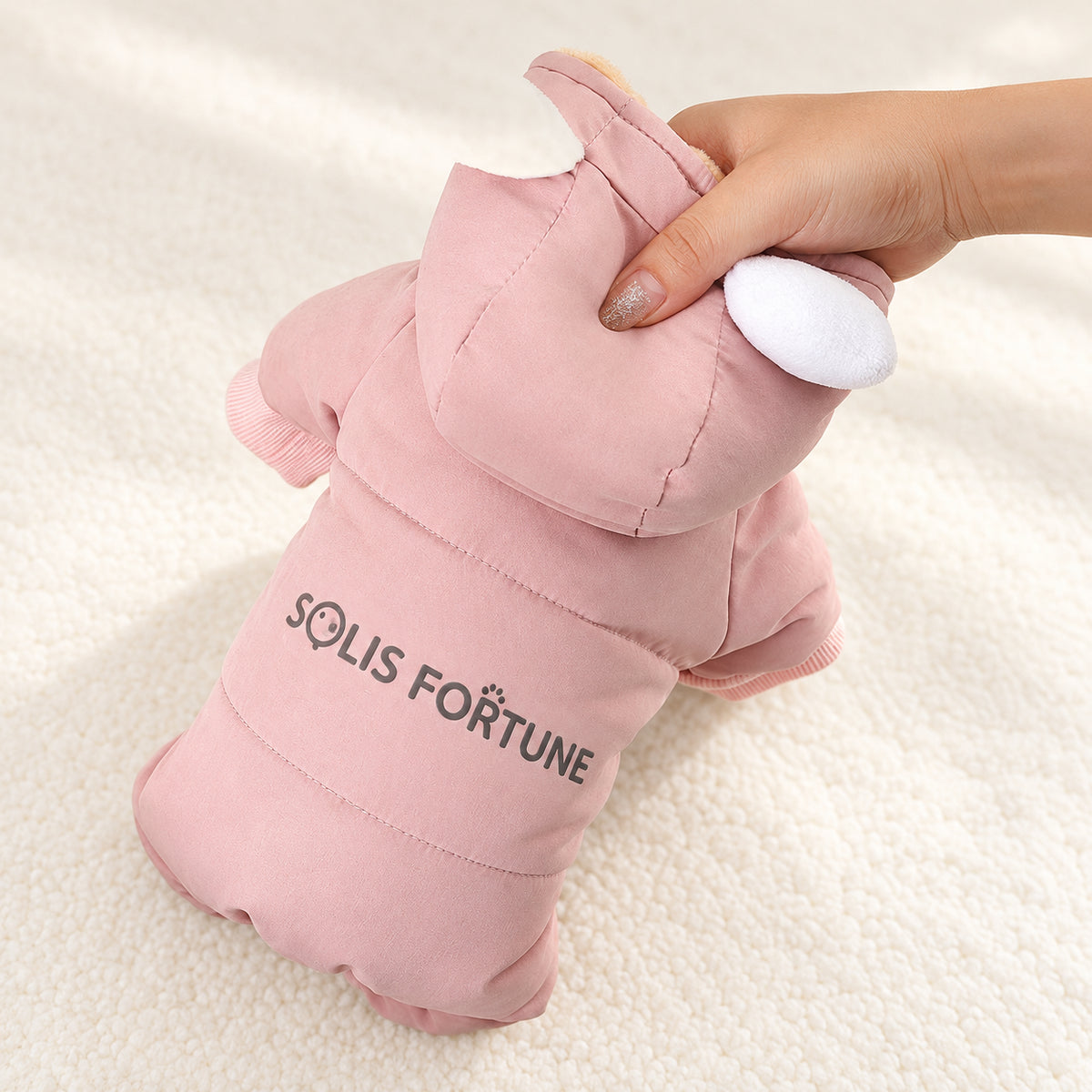 Solis Frostpaw — padded pink dog jumpsuit held up to show the thick fill