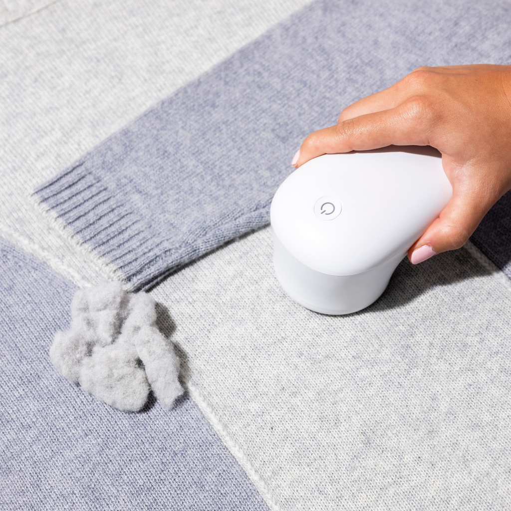 Solis Fuzzaway — fabric shaver gliding over a pilled wool blanket