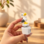 Solis Gull — screaming seagull button keychain held between fingers