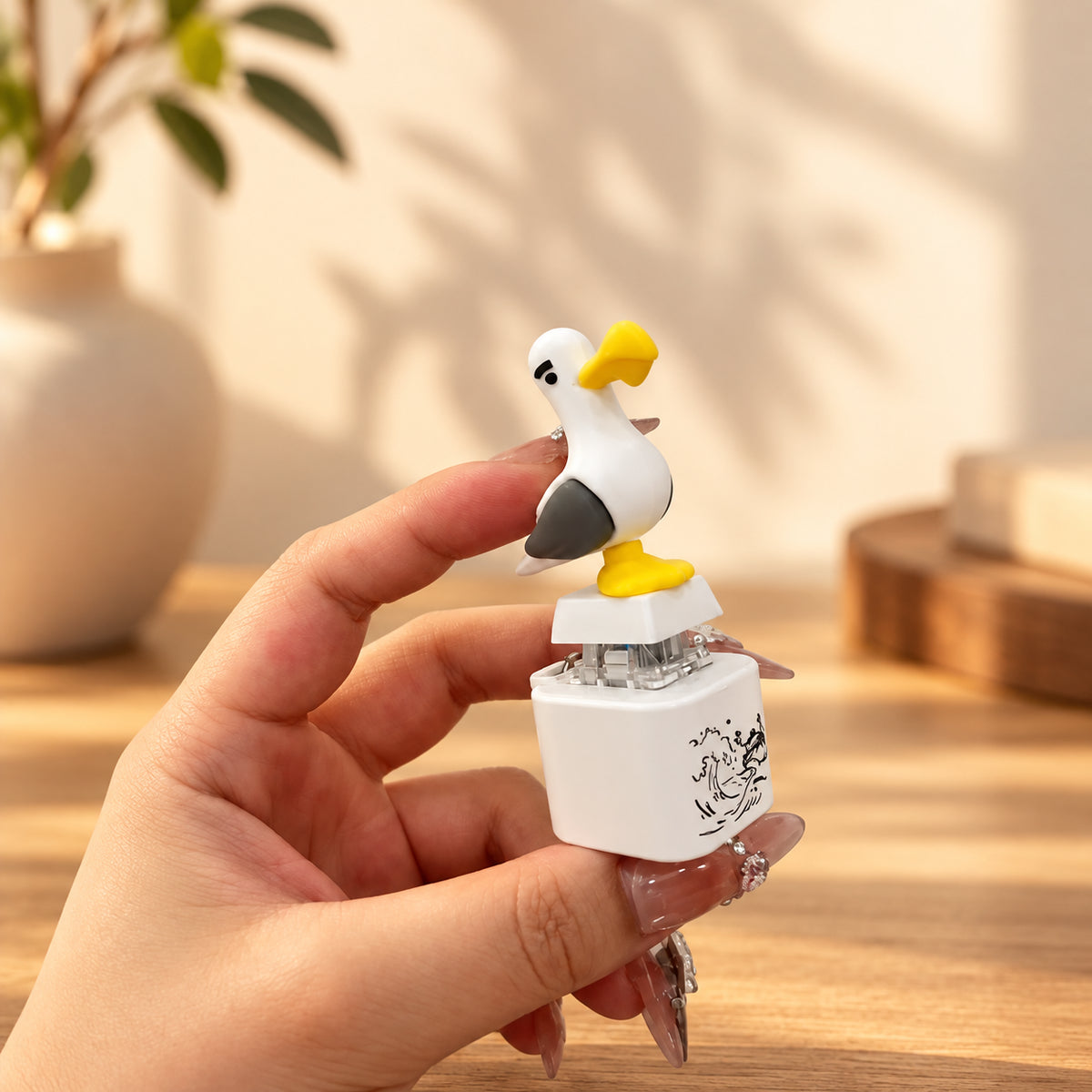 Solis Gull — screaming seagull button keychain held between fingers