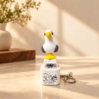 Solis Gull — MINE seagull keychain standing on its white button base