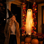 Solis Hollow Swinging Ghost hanging on a porch beside a woman in a witch hat