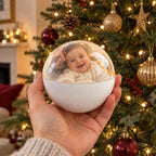 Solis Keepsake Orb — memory orb Christmas ornament with a baby video, held in front of the tree