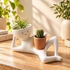Solis Lazy Bloom — body planter on a desk with an air plant and a small cactus