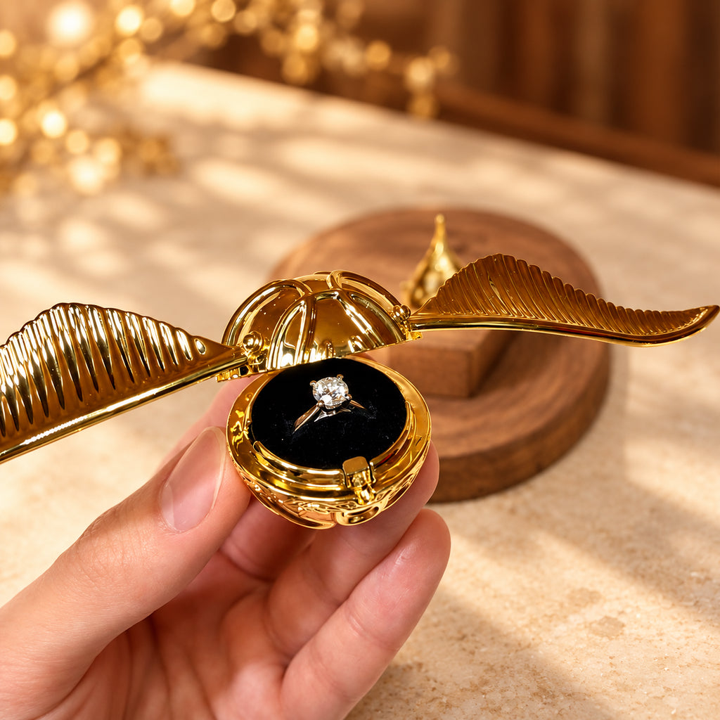 Solis Seeker — Golden Snitch ring box open with an engagement ring on the velvet insert
