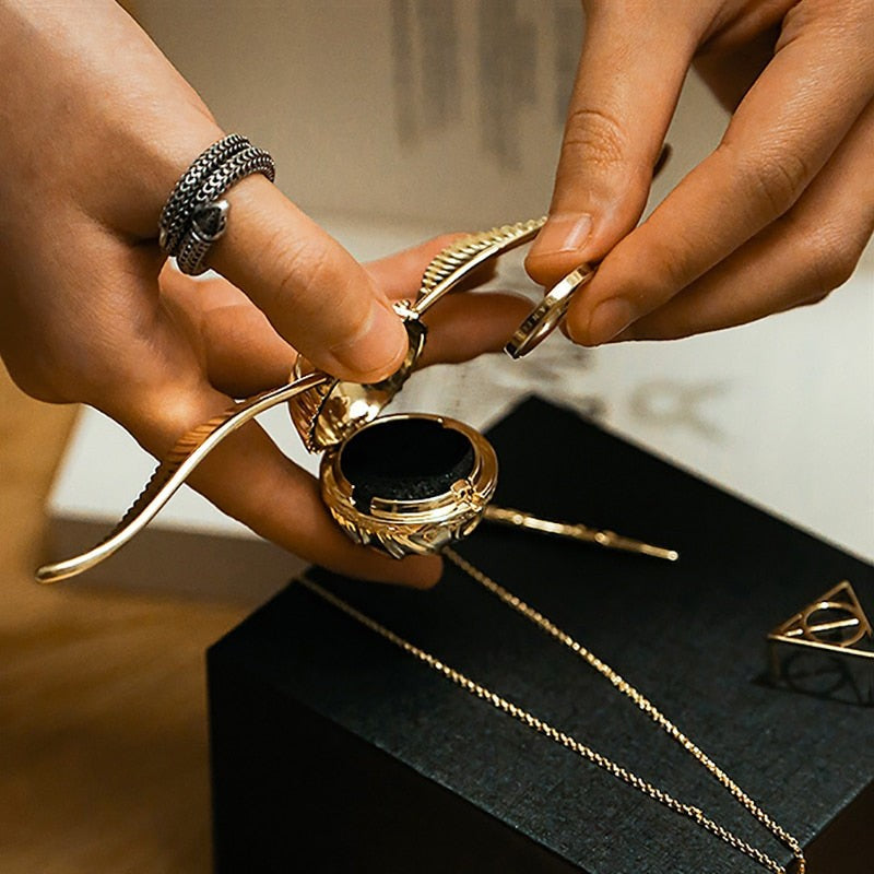 Solis Seeker — hands holding the open snitch ring box with the wand key and necklace chain