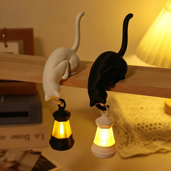 Solis Shelf Cat — white and black cat bookshelf lanterns glowing on a shelf edge