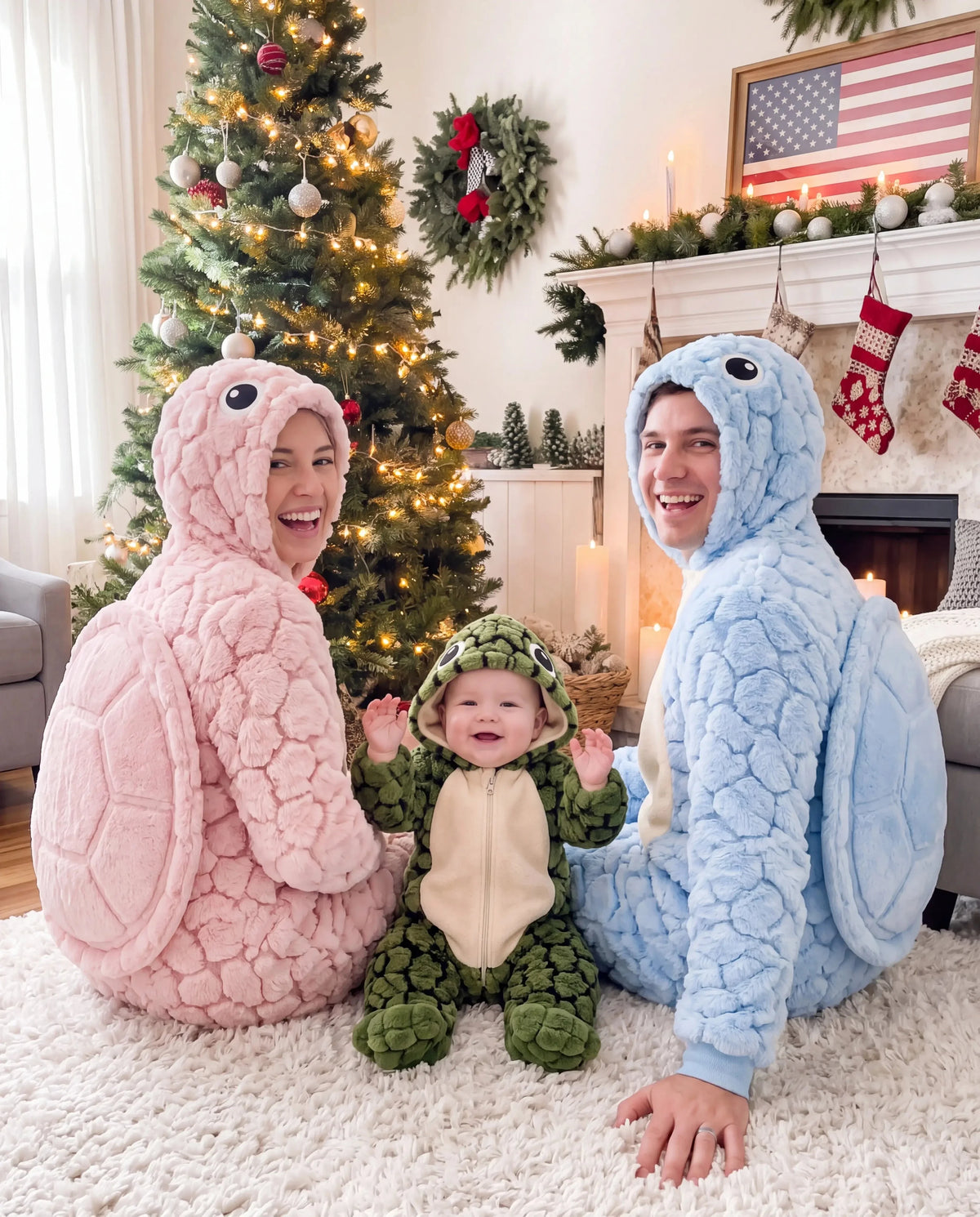 Two parents in pink and blue Solis Shell onesies with a baby in green, sitting by a Christmas tree
