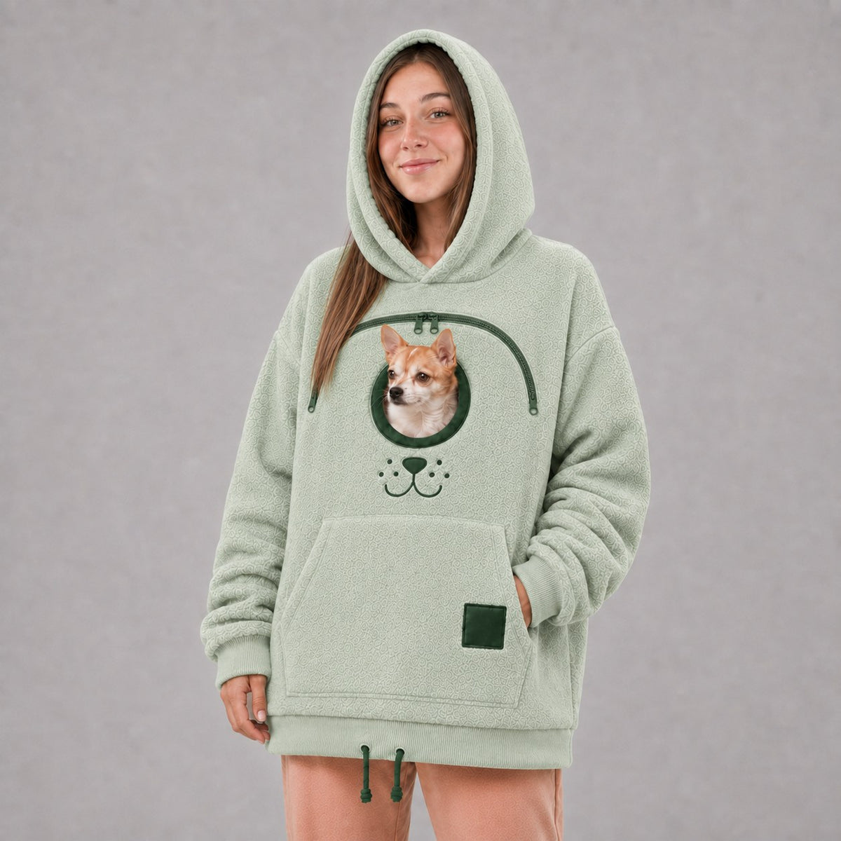 Solis Snuggle Pet Pouch Hoodie in sage green with a small dog in the pouch